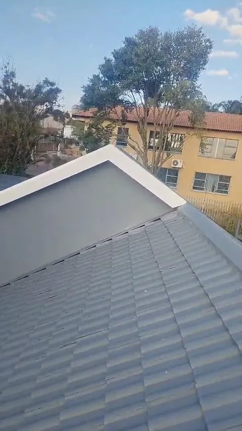 Concrete tiled roof freshly painted grey, with painted gable and ridge