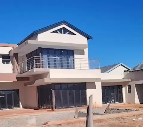 Double-storey home with charcoal fascia boards, charcoal aluminium folding doors and a stainless steel balcony balustrade