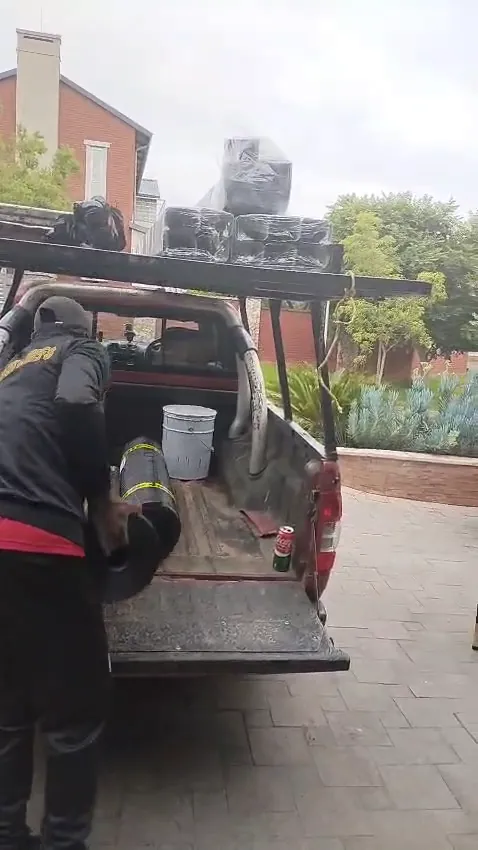 Rolls of torch-on waterproofing membrane being offloaded from a bakkie on site